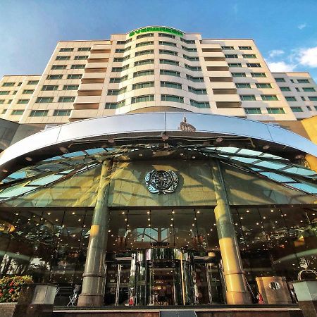 Evergreen Laurel Hotel - Tchaj-čung Exteriér fotografie The photo shows the exterior of a modern hotel building. The entrance features a large, glass canopy supported by columns, creating a welcoming area. The facade of the hotel is composed of a mix of glass and concrete, with large windows that suggest 