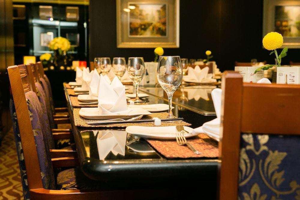 Evergreen Laurel Hotel - Tchaj-čung Exteriér fotografie The photo depicts a dining table set for a formal meal. The table is long, covered with a dark tablecloth, and has neatly arranged plates, forks, and glasses at each setting. White napkins are folded elegantly, and there are small yellow flowers as c