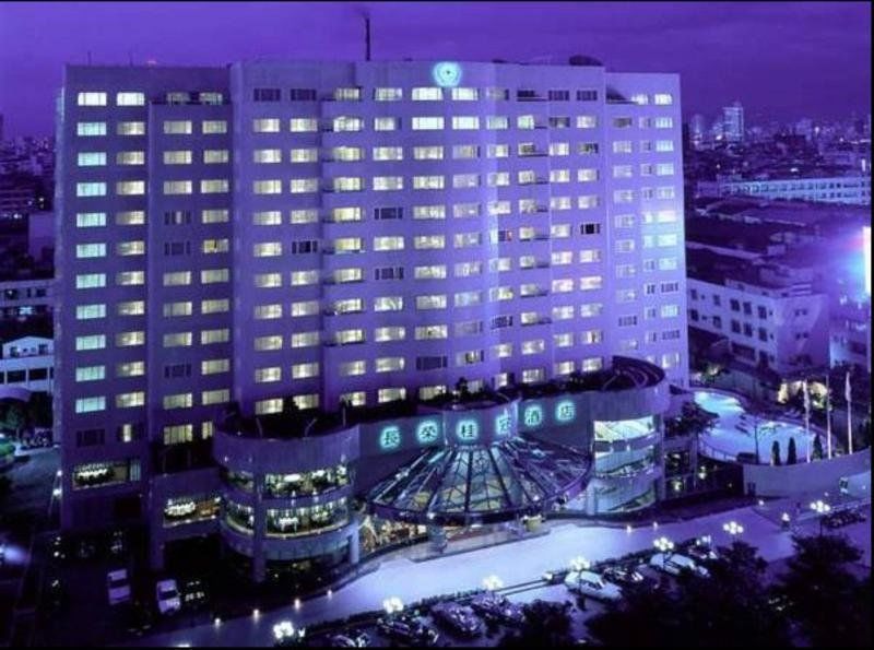 Evergreen Laurel Hotel - Tchaj-čung Exteriér fotografie The photo shows a large hotel building illuminated in a purple hue during the evening or nighttime. The facade features numerous windows, many of which are lit, suggesting occupancy. The entrance area appears modern and curved, with a design that inc