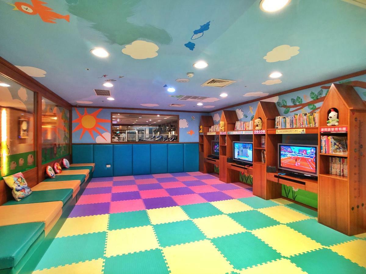Evergreen Laurel Hotel - Tchaj-čung Exteriér fotografie The photo shows a brightly colored children's playroom or activity area. The floor is covered with large colorful tiles in shades of blue, green, yellow, and pink, creating a playful pattern. The walls have cheerful decorations, including sun and clo