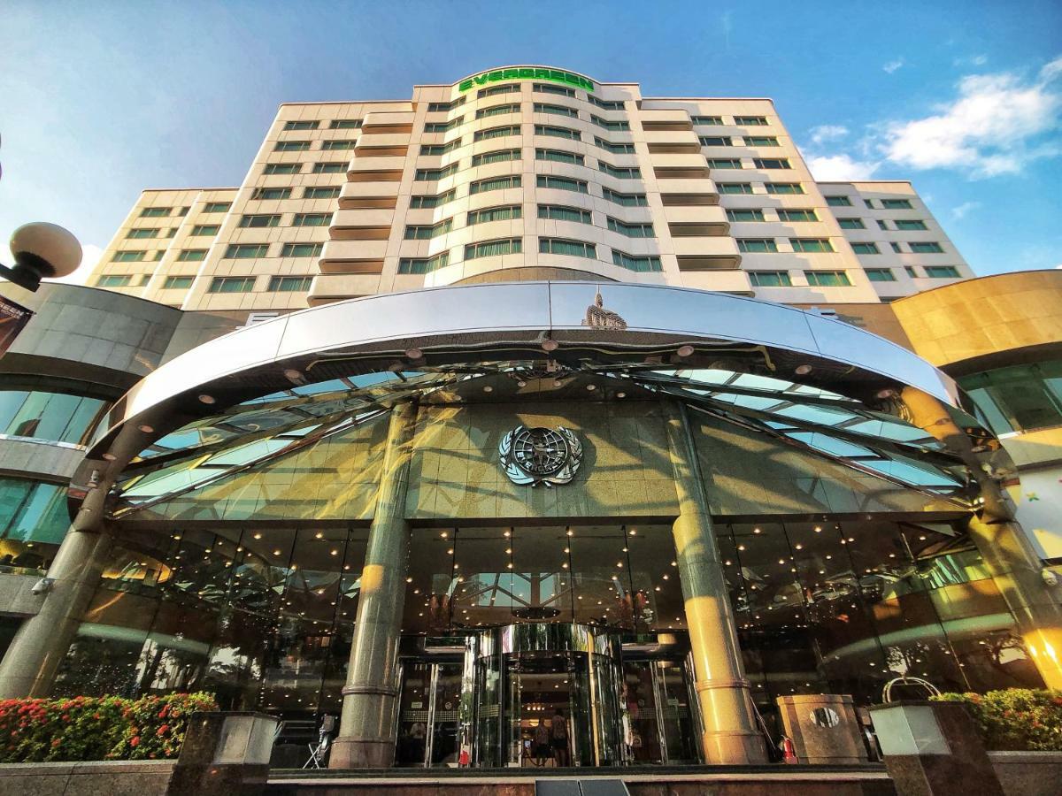 Evergreen Laurel Hotel - Tchaj-čung Exteriér fotografie The photo shows the exterior of a modern hotel building. The entrance features a large, glass canopy supported by columns, creating a welcoming area. The facade of the hotel is composed of a mix of glass and concrete, with large windows that suggest 