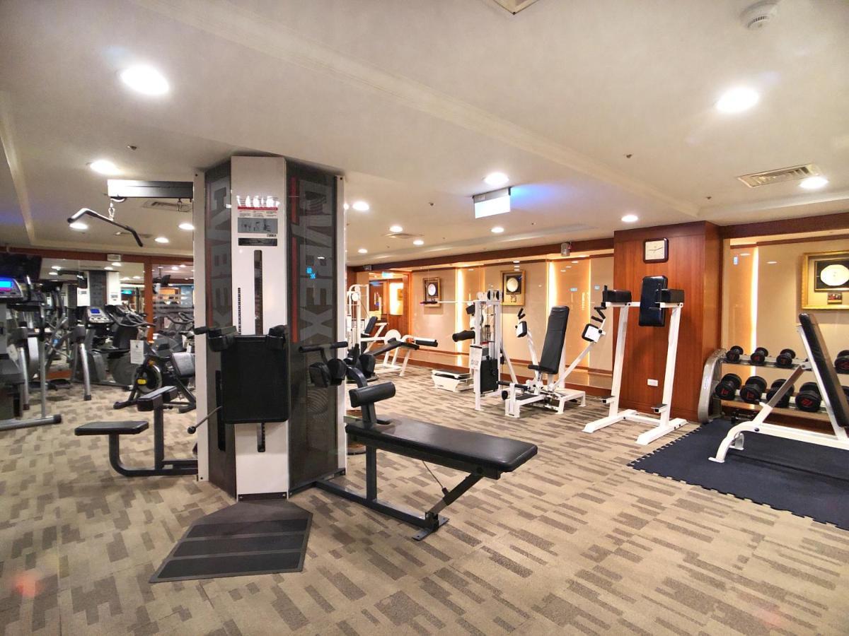 Evergreen Laurel Hotel - Tchaj-čung Exteriér fotografie The photo shows an indoor gym or fitness area. It features various workout equipment, including:

- A multi-station gym machine in the center for strength training.
- Weight benches and free weights organized on shelves.
- Cardio equipment, likely tr