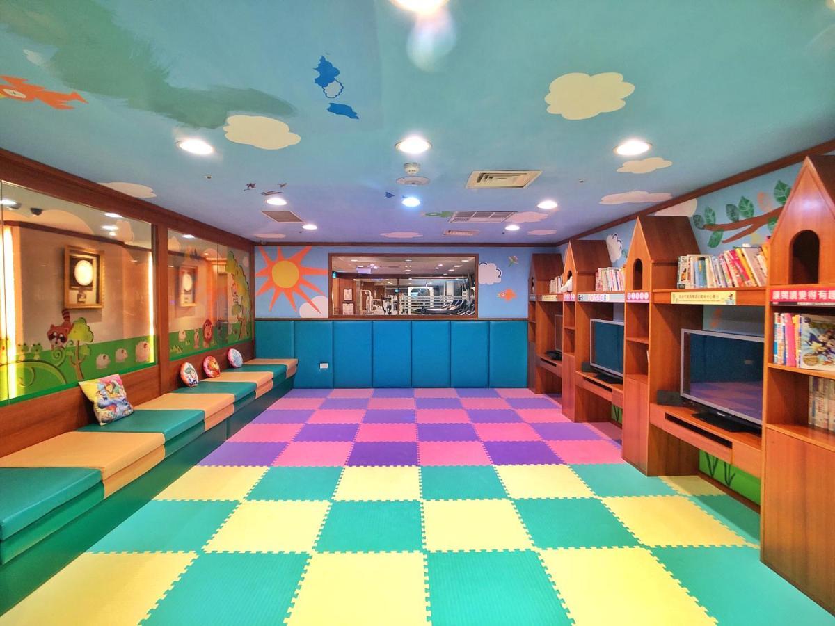 Evergreen Laurel Hotel - Tchaj-čung Exteriér fotografie The photo shows a colorful children's playroom or reading area. The ceiling is painted blue with clouds, creating a cheerful atmosphere. On the floor, there is a soft, interlocking mat with alternating pastel colors, including pink, green, and yellow